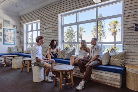 The hostel reception at Wake Up! Bondi Beach is a spacious, beachy common area where travellers are encouraged to chill, read, or mix with other guests