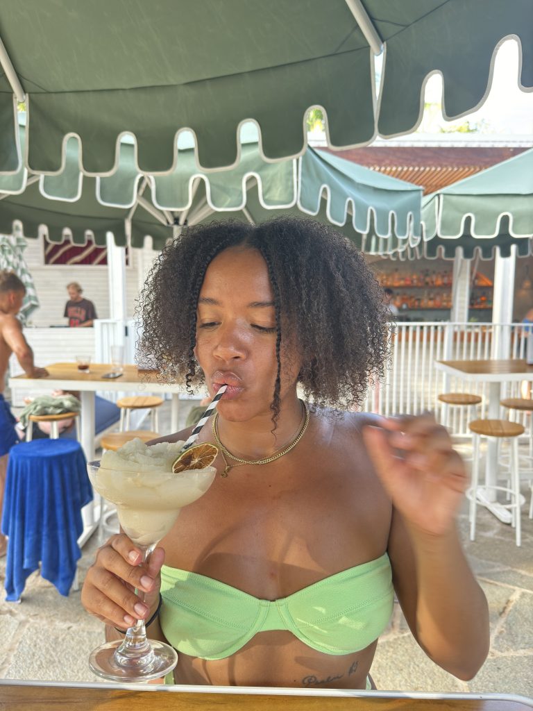 Ayana @_postcardsfromayana enjoying drinks at The Pool Bar at Wake Up! Byron Bay hostel.